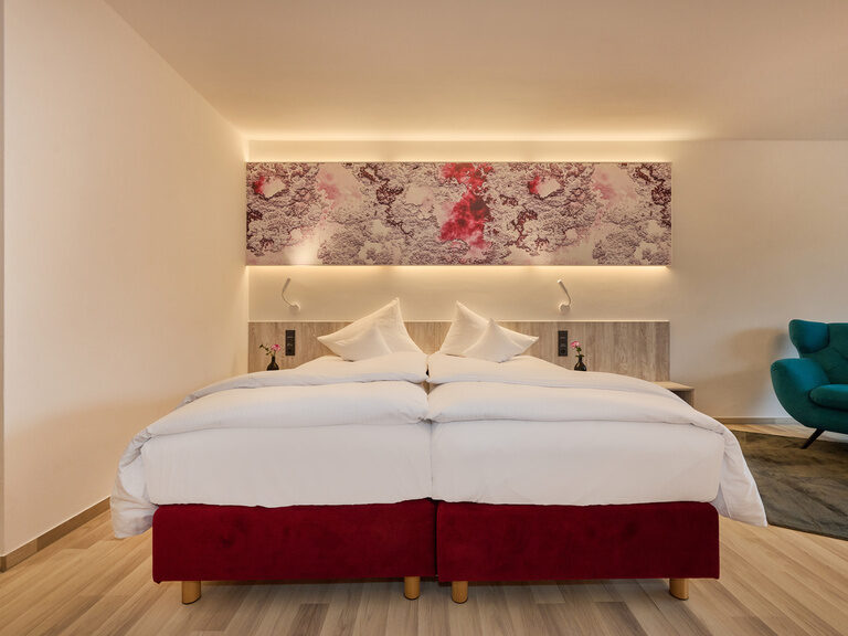 Modernes Hotelzimmer mit Doppelbett und indirekter Beleuchtung.