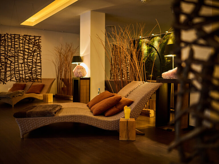 Gemütlicher Ruhebereich mit Korbliegen, indirektem Licht und natürlichen Dekoelementen.