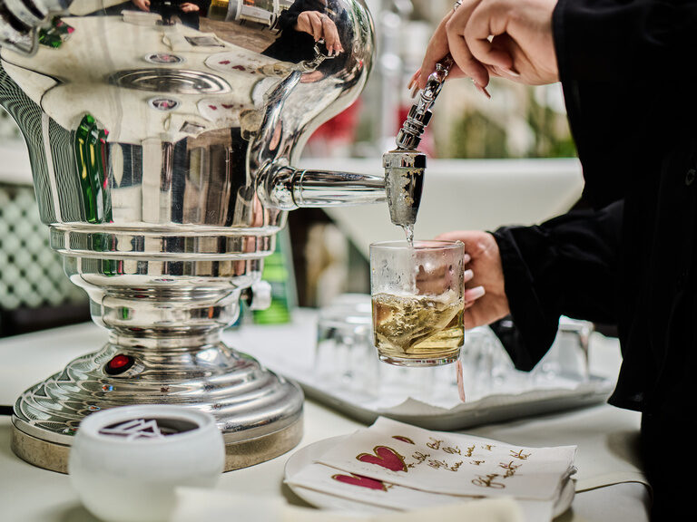 Tee läuft aus Samowar in Glas mit Teebeutel am Buffet.