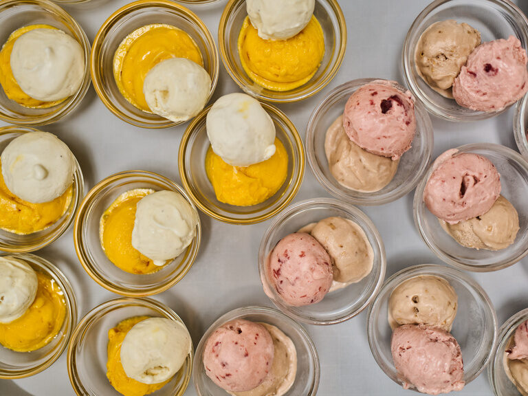 Dessertschalen mit Eiskugeln in Gelb, Weiß und Rosa.