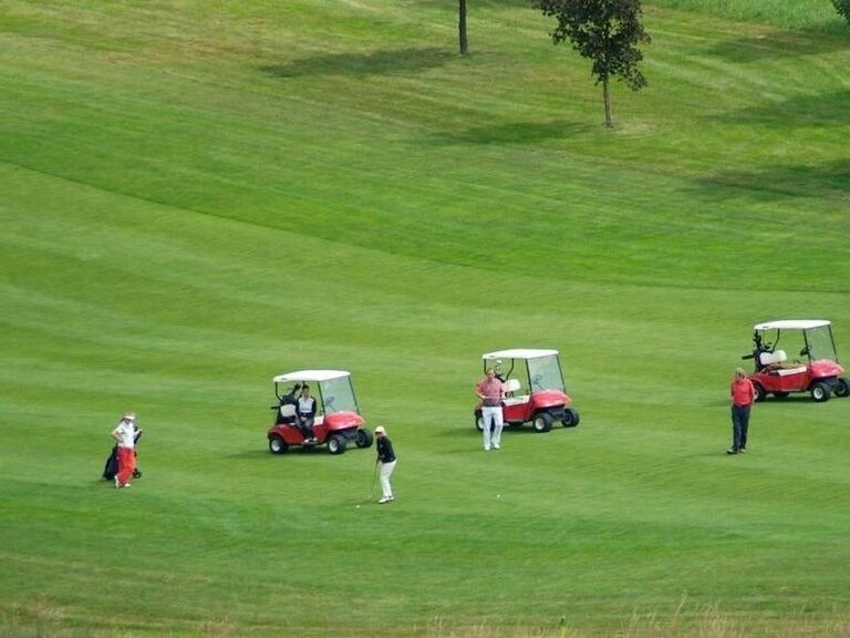 Mehrere Golfcarts unterwegs auf dem Golfplatz nahe dem Hotel Wutzschleife.
