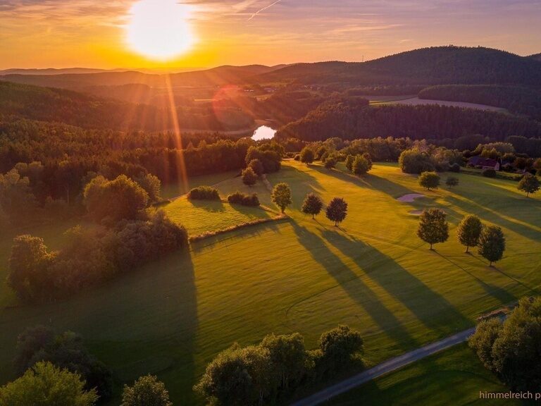 Luftaufnahme des 18-Loch-Golfplatzes nahe dem Hotel Wutzschleife bei Sonnenuntergang.