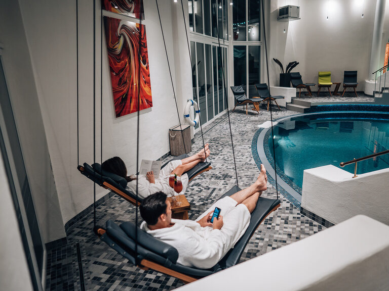 Paar in Handtüchern genießt die wohltuende Wärme der Holzsauna im Hotel Wutzschleife.