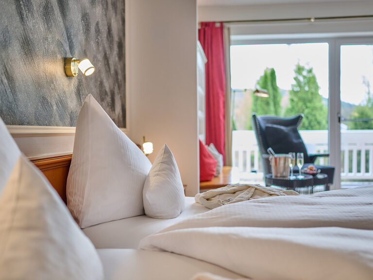 Helles Hotelzimmer im Hotel Wutzschleife mit stilvoll weiß bezogenem Bett